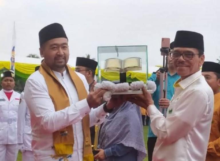 Wakil Gubernur Audy Joinaldy menyerahkan piala juara umum kepada Bupati Limapuluh Kota Safaruddin Dt Bandaro Rajo usai penutupan MTQ Nasional XL tingkat Sumbar di Solok Selatan, Minggu (17/12). (Dok : Istimewa)