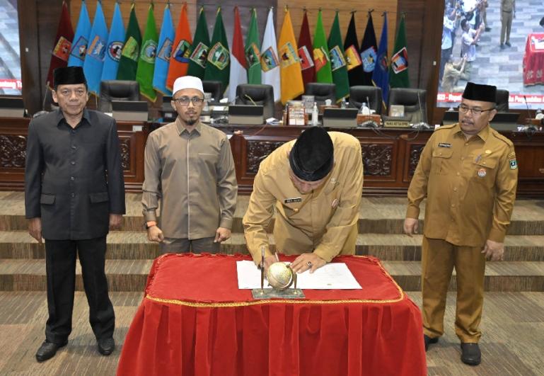 Gubernur Mahyeldi disaksikan dua Wakil Ketua DPRD Sumbar Irsyad Syafar dan Suwirpen Suib tandatangani dokumen pengesahan Perda Tanah Ulayat, di Padang, Senin (4/12). (Dok : Istimewa)