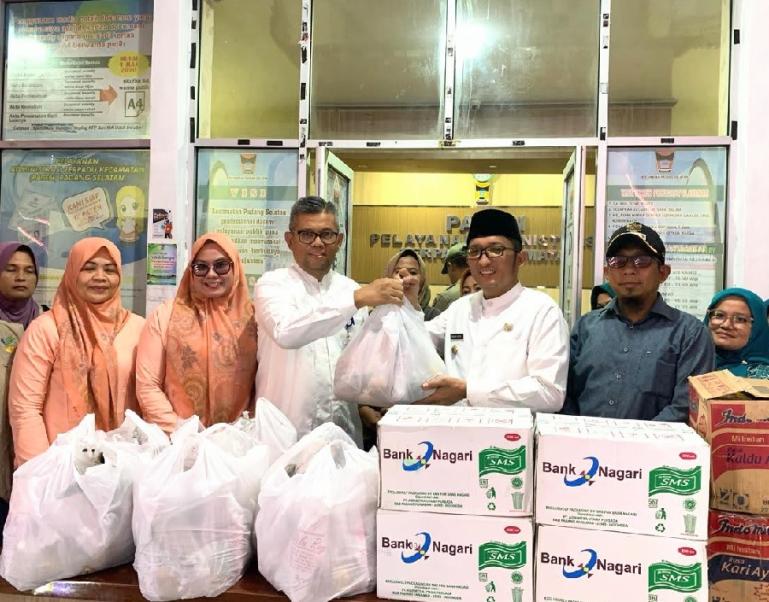 Pemimpin Bank Nagari Cabang Pasar Raya Hendri Masri menyerahkan bantuan untuk korban banjir kepada Wali Kota Padang Hendri Septa, di Kantor Camat Padang Selatan, Jumat (8/3). (Dok : Istimewa)