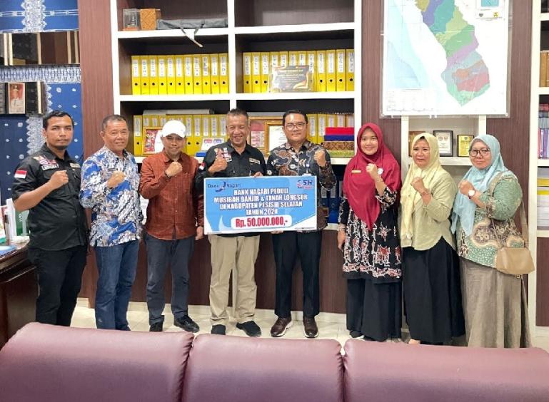 Pemimpin Bank Nagari Cabang Painan Helfiyanrika saat menyerahkan dana bantuan bagi korban banjir di Pesisir Selatan sebesar Rp50 juta yang langsung diterima Bupati Pessel Rusma Yul Anwar, Kamis (14/3). (Dok : Istimewa)