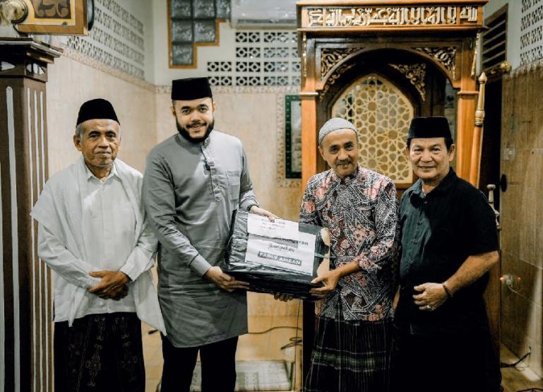 Ketua DPW NasDem Sumbar, Fadly Amran didampingi Ketua DPD NasDem Padang, Osman Ayub serahkan bantuan kepada pengurus Masjid Jihad, Kandis, Nanggalo, Jumat malam (15/3). (Dok : Istimewa)