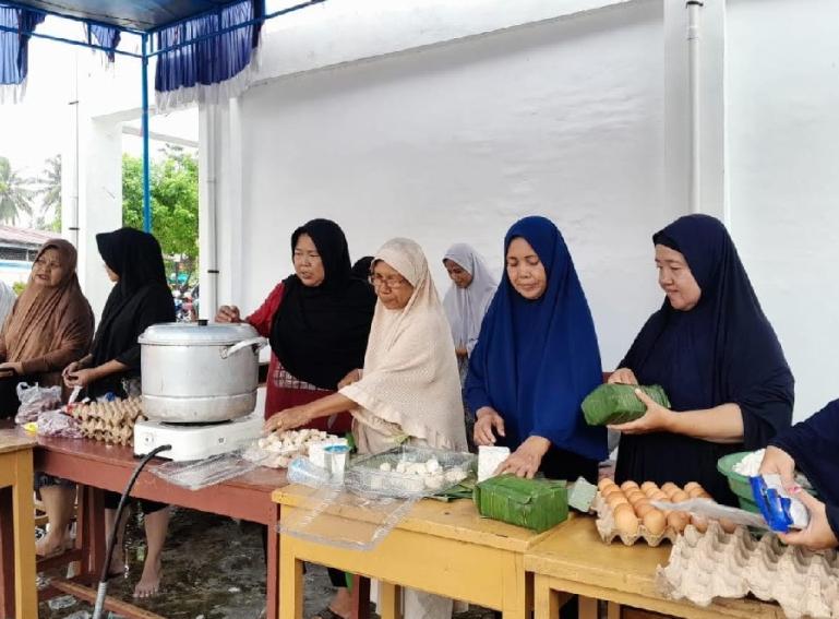Ibu-ibu di salah satu komplek perumahan sedang memasak pada dapur umum yang didirikan DPW PKS Sumbar, bagi masyarakat terdampak banjir, Jumat (8/3). (Dok : Istimewa)