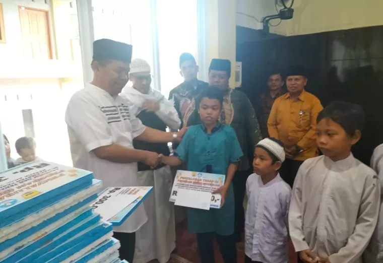 Sekretaris Dikopora Kota Pariaman, Masrimpi Noor serahan bantuan infaq dari PTK SD Pariaman Utara kepada puluhan anak kurang mampu, Rabu 3 April 2024. (Dok : Istimewa)