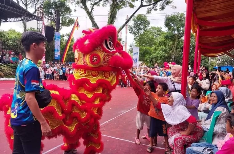 Pengunjung berebut mengambil jeruk yang dilontarkan oleh barongsai dalam Festival Rakyat Muaro Padang Tempo Doeloe, Sabtu (20/4/2024). Facebook Diskominfo Kota Padang