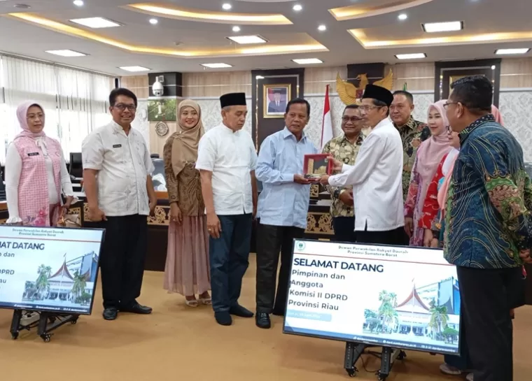 Sekretaris DPRD Sumbar, Raflis tukar cinderamata dengan Ketua Komisi II DPRD Riau, Syafrudin Ibun di ruang khusus 1 DPRD Sumbar, Jumat (5/4/2024 ). (Dok : Humas DPRD Sumbar)