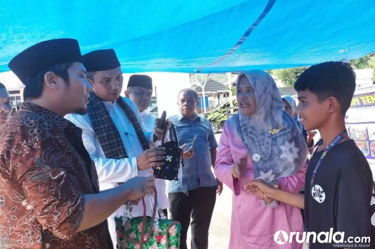 Ketua UMKM Kota Padang Dean Asli Chaidir didamping Camat Lubeg Andi Amir melihat produk dari PKBM Daur Ulang Amak dalam bazar yang diadakan pihak kecamatan setempat, Kamis (25/4/2024). (Dok : Arunala.com)