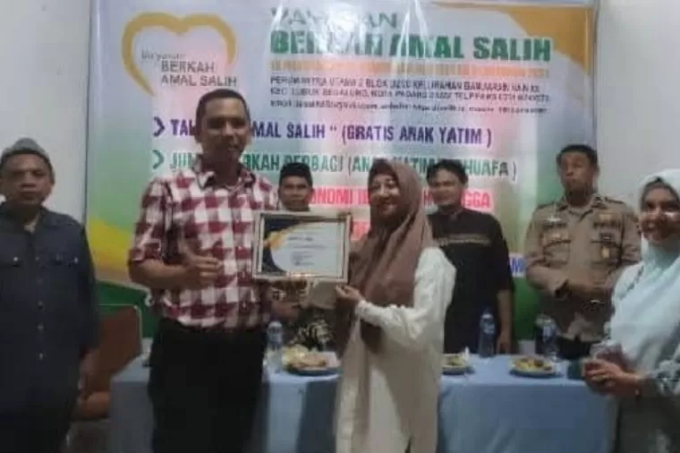 Camat Lubeg, Noviandi Amir berikan piagam penghargaan kepada Herwaty Taher atas partisipasinya di Kelurahan Banuaran Nan XX, beberapa waktu lalu. (dok: istimewa)