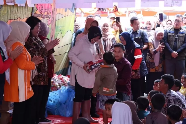 Menteri Sosial RI Tri Rismaharini menyerahkan mainan kepada anak-anak di posko pengungsian Parambahan Tanahdatar, Kamis (16/5/2024). Kominfo Tanah Datar