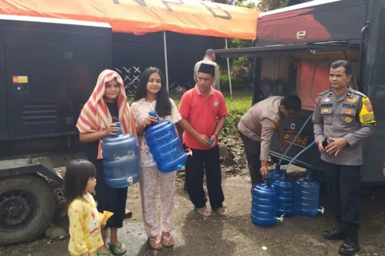Sejumlah warga menampung air bersih yang disuplai Polda Sumbar menggunakan mobil water treatment portable di Nagari Rambatan, Tanahdatar, Rabu (15/5/2024). (dok : humas polda sumbar)