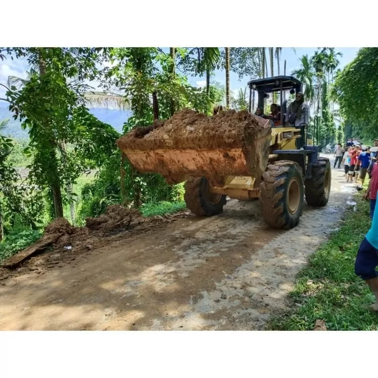 Alat berat yang dikirimkan oleh tim dari BPBD membersihkan timbunan longsor di jalan yang menghubungkan Nagari Bomas dan Nagari Koto Baru, Senin (13/5/2024). Humas Pemkab Solsel