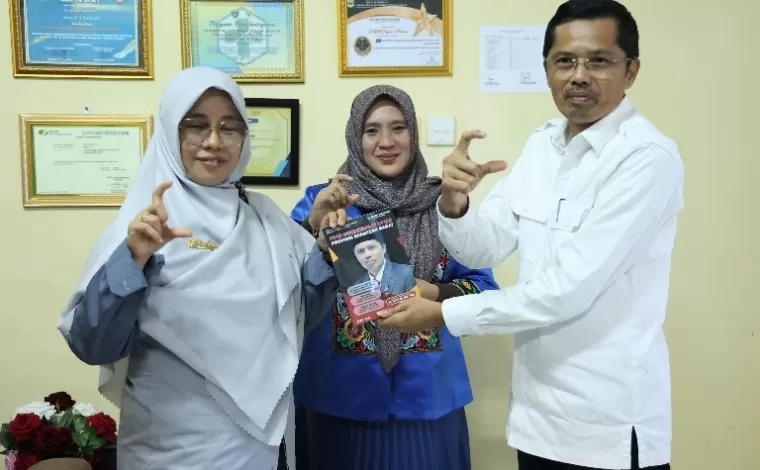 Sekretaris DPRD Sumbar, Raflis serahkan buku kinerja PPID DPRD Sumbar kepada Kepala SMAN 3 Painan Rini Amelia disaksikan Wakil Ketus KI Sumbar, Tanti Endang Lestari di Painan, Senin (6/5/2024) kemarin. (Dok : Istimewa)