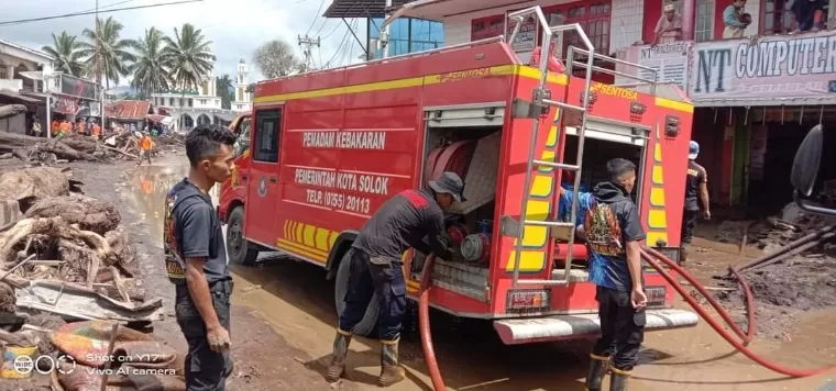 Personel Unit Damkar terus berupaya membersihkan rumah warga. Kominfo Tanahdatar