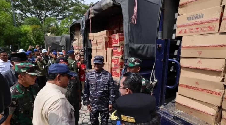 Mengenakan topi biru, Menhan Prabowo melakukan pengecekan bantuan logistik di dalam puluhan truk saat penyerahan bantuan bencana alam untuk Sumbar, Kamis (16/5/2024). Humas Kemhan RI
