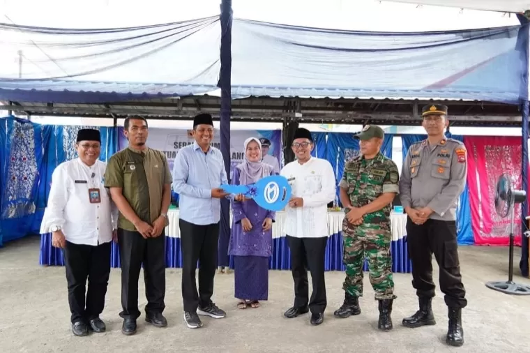 Bupati Tanahdatar Eka Putra menyerahkan bantuan satu unit mobil ambulance yang diterima Wali Nagari Pangian Hijrah Adi Sukrial, di halaman Kantor Wali Nagari setempat, Jumat (28/6/2024). Prokopim Tanah Datar