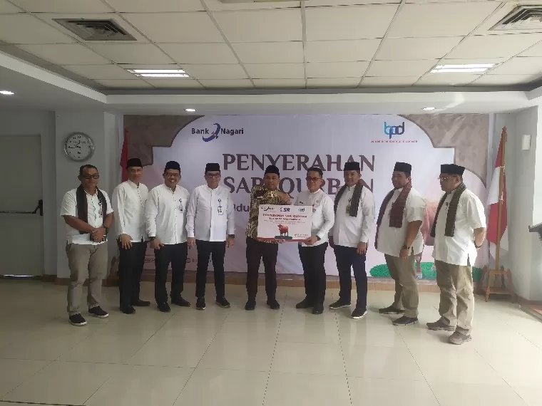 Pjs Direktur Utama Bank Nagari Gusti Candra menyerahkan secara simbolis lima ekor sapi ke Kepala Biro Kesra Setprov Sumbar Al Amin di Aula Lantai IV Kantor Pusat Bank Nagari, Jumat (14/6/2024). IST