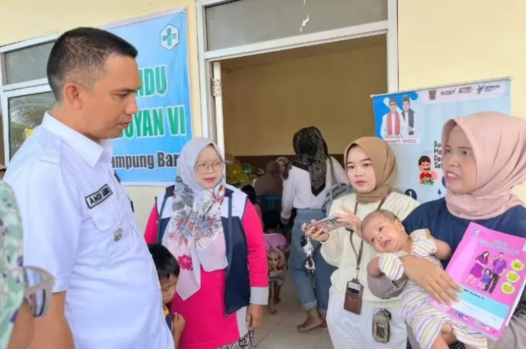 Camat Lubeg, Andi Amir berdialog dengan warga yang memeriksakan kondisi bayinya di Posyandu  Flamboyan VI Kelurahan Kampung Baru Nan XX, Lubeg, Rabu (5/6/2024). (dok : istimewa)