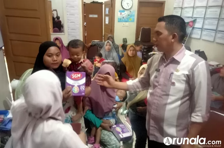 Camat Lubeg, Andi Amir didampingi dr Sari saat berikan paket makanan tambahan pada bayi dan balita, di Balai Penyuluhan KB Kantor Lurah Pegambiran, Jumat (21/6/2024). (dok : arunala.com)