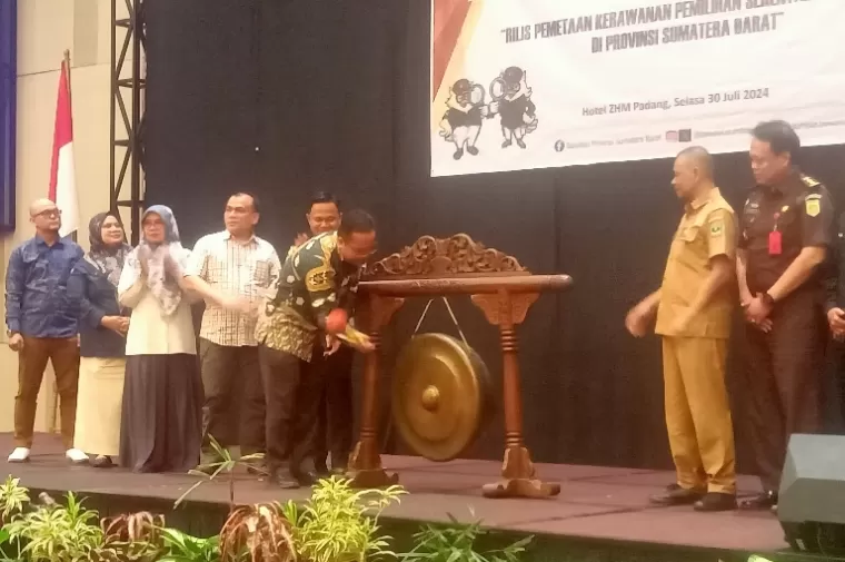 Ketua Bawaslu Sumbar, Alni didampingi pihak Forkopimda pukul gong dimulainya kegiatan rilis IKP pemilihan 2024 Sumbar, di Padang, Selasa (30/7/2024). (dok : arunala.com)