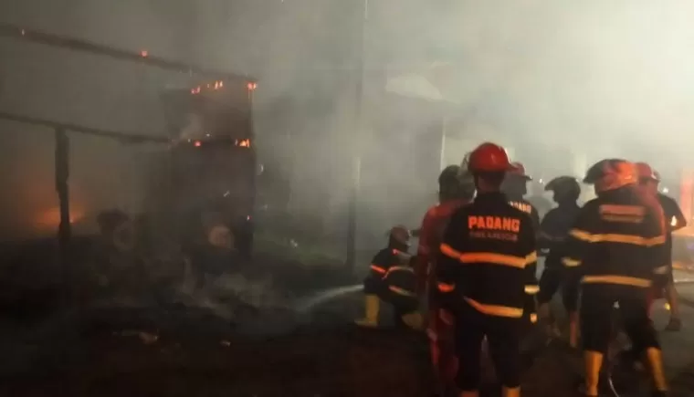 Petugas Damkar Kota Padang melakukan pemadaman api yang membakar satu unit bengkel truk di Jalan Raya By Pass, Batung Taba, Selasa malam (13/8/2024). (dok : damkar padang)