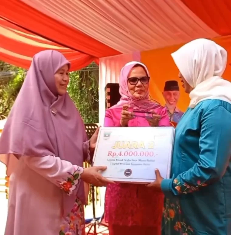 Ketua Forikan Sumbar Harneli Bahar didampingi Kadis DKP Sumbar Dr Ir Reti Wafda MTp menyerahkan hadiah kepada pemenang lomba masak serba ikan kategori menu balita, di halaman Gedung Rohana Kudus, Sabtu (31/8/2024). IST