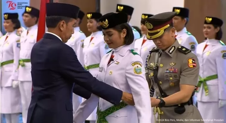 Presiden Joko Widodo (Jokowi) secara simbolis mengukuhkan Paskibraka Tingkat Pusat Tahun 2024 kepada Violetha Agryka Sianturi mewakili rekan-rekannya, di Istana Garuda, Ibu Kota Nusantara (IKN), Selasa (13/8/2024). YouTube Sekretariat Presiden