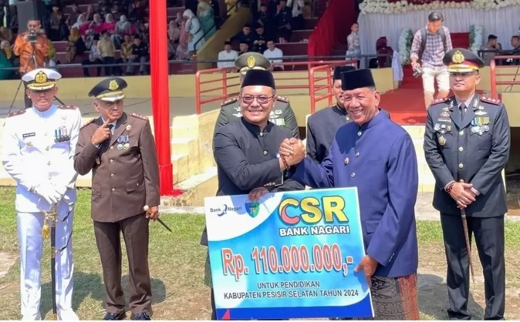 Pemimpin Cabang Bank Nagari Painan Helfiyanrika menyerahkan CSR Pendidikan kepada Bupati Pesisir Selatan, Rusma Yul Anwar saat upacara HUT ke-79 Kemerdekaan Republik Indonesia di GOR H Ilyas Yakub Painan, Sabtu (17/8/2024). IST
