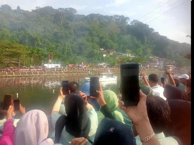 Pasangan Fadly-Maigus menaiki perahu menyapa masyarakat yang ada di dua sisi Sungai Batang Arau Padang, sebelum deklarasi dimulai, Minggu sore (18/8/2024). (dok : arunala.com)