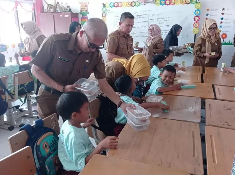 Asisten Administrasi Umum Setko Padang Corri Saidan saat memberikan kudapan pangan bergizi di SDN 09 Surau Gadang, Senin (26/8/2024). Diskominfo Kota Padang