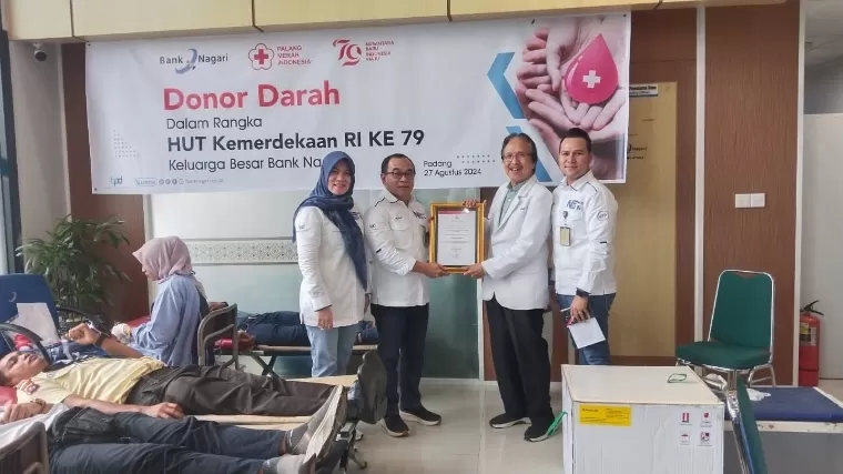 Pemimpin Divisi Kepatuhan Bank Nagari Eka Andria Putra menerima sertifikat dari  Kepala UTD PMI Kota Padang dr Widyarman saat aksi donor darah di lantai 1 Bank Nagari Cabang Utama, Selasa (27/8/2024). IST