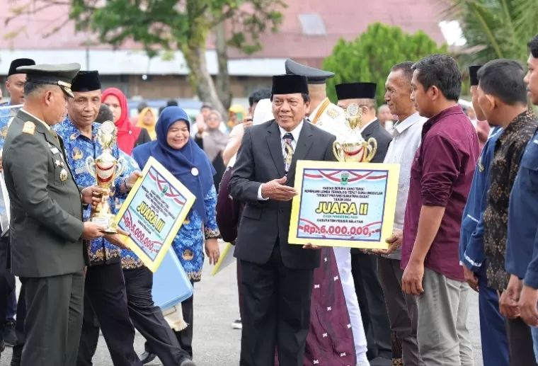 Wakil Ketua DPRD Sumbar, Suwirpen Suib serahkan hadiah  kepada pemenang lomba teknologi tepat guna sesuai upacara penurunan bendera di lapangan Istana Gubernuran Sumbar, Minggu sore (18/8/2024). (dok : humas dprd sumbar)