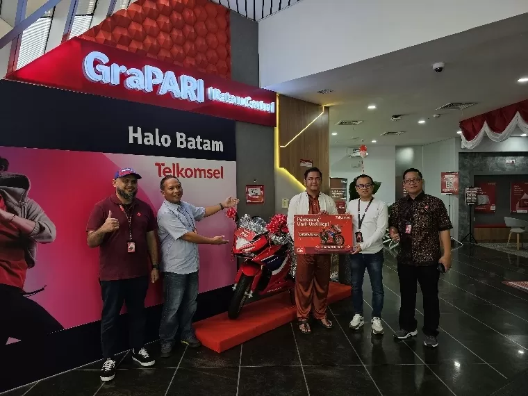 Adittya Pratama (tengah) resmi menjadi pemenang hadiah motor sport program Undi Undi Hepi Periode 4 dari Telkomsel yang diserahkan oleh Manager Mobile Consumer Branch Batam, Muhammad Syahrir di GraPARI Batam Center, Kamis (22/8/2024). IST