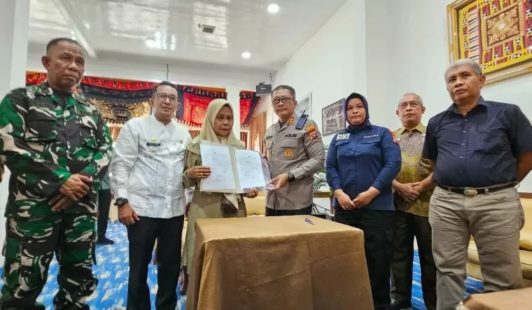 Kapolres Tanahdatar AKBP Derry Indra didampingi Bupati Tanahdatar Eka Putra menyerahkan berita acara penyerahan potongan tubuh kepada pihak keluarga korban di Indojolito Batusangkar, Sabtu (10/8/2024). Prokopim Tanah Datar