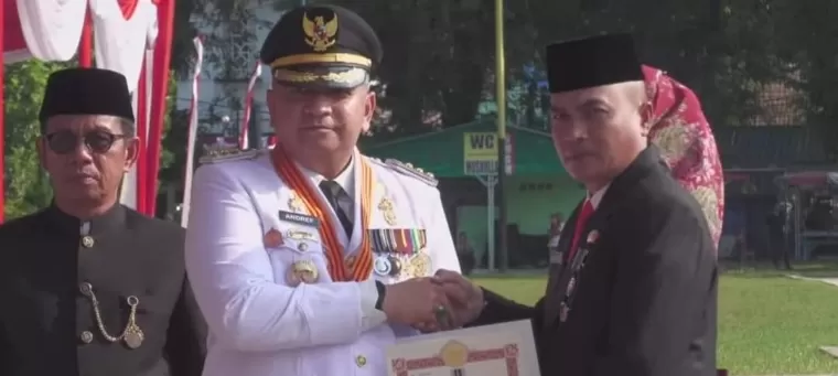 Pj Wali Kota Padang Andree Algamar menyerahkan piagam penghargaan tanda kehormatan Satyalancana Karya Satya dari Presiden Republik Indonesia, Joko Widodo saat Upacara HUT ke-79 RI, di Lapangan Imam Bonjol, Sabtu (17/8/2024). Diskominfo Kota Padang