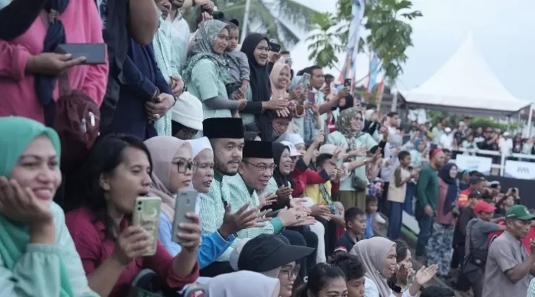 Pasangan bakal calon Wali Kota dan Wakil Wali Kota Padang, Fadly-Maigus bersama masyarakat saat saksikan final Salaju Sampan Sarangkuah, di Sungai Batang Arau, Kota Padang, Minggu (18/8/2024). (dok : istimewa)