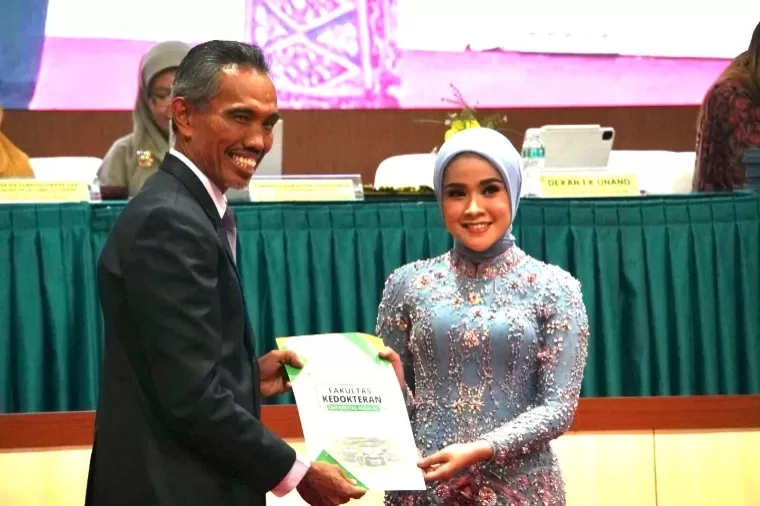 Dekan FK Unand Prof Dr dr Afriwardi SH SpKO MA Subs APK (K) menyerahkan piagam penghargaan kepada lulusan terbaik dr Shafana Vinda Shabira saat Yudisium dan Sumpah Profesi Dokter di Aula Student Center M Syaaf FK Unand Jati, Rabu (28/8/2024). IST