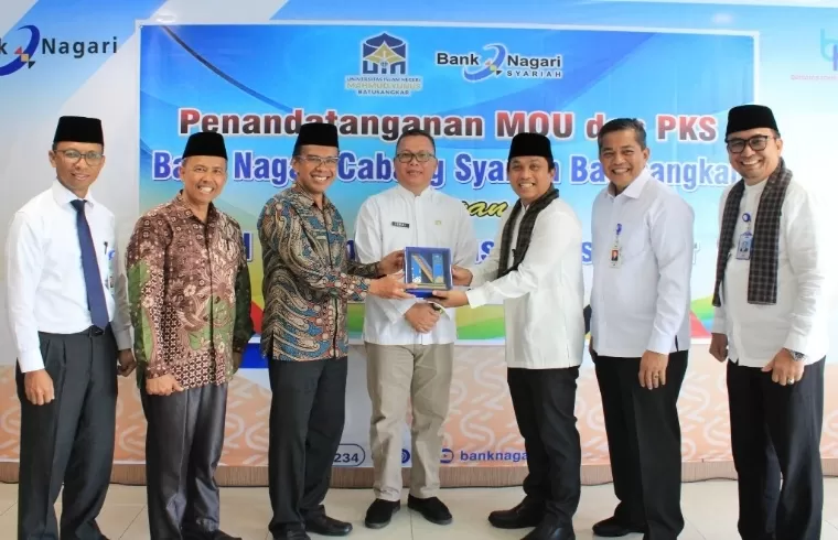 Direktur Utama Bank Nagari Gusti Candra menyerahkan cinderamata kepada Rektor UIN Mahmud Yunus Batusangkar Rektor Prof Delmus Puneri Salim MA MRes PhD di Aula Lantai IV Kantor Pusat Bank Nagari, Jumat (13/9/2024). Humas Bank Nagari