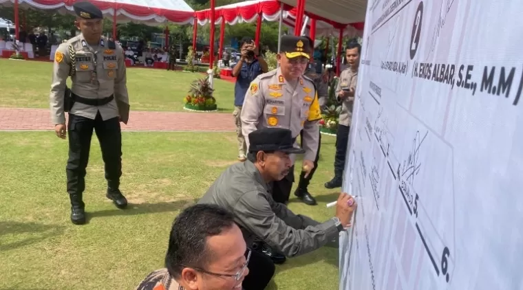 Kapolda Sumbar, Irjen Pol Suharyono saksikan Ketua KPU Surya Efitrimen dan Ketua Bawaslu Alni tanda tangani spanduk deklarasi damai pilkada Sumbar bermartabat di Mapolda Sumbar, Selasa (24/9/2024). (dok : istimewa)