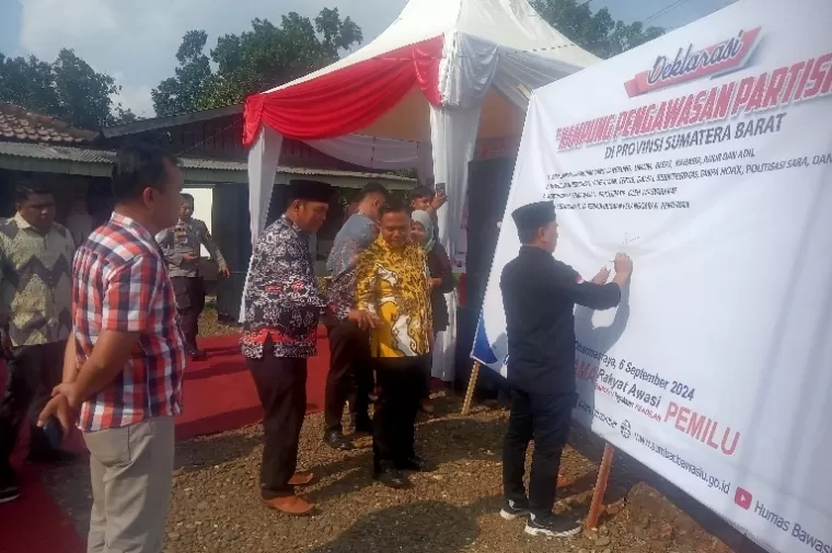 Unsur pimpinan Bawaslu Sumbar, Muhammad Khadafi bersama perangkat daerah di Kabupaten Dharmasraya serta semua Panwascam bubuhkan tanda tangan pada spanduk deklarasi pilkada damai di Kecamatan Tiumang, Jumat sore (6/9/2024). (dok : arunala.com)