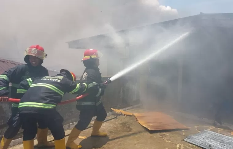 Para petugas Damkar berusaha memadamkan api yang membakar rumah millik ASN Polri di Ampang, Kuranji, Padang, Jumat siang (13/9/2024). (dok : istimewa)