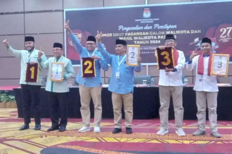 Tiga paslon Wali Kota dan Wakil Wali Kota memperlihatkan nomor urut yang mereka peroleh saat pengundian yang diadakan KPU Kota Padang, Senin (23/9/2024). (dok : arunala.com)