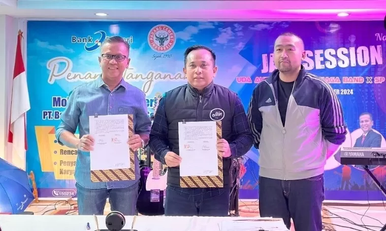 Direktur Utama Bank Nagari Gusti Candra dan Direktur Utama PT Semen Padang Indrieffouny Indra memperlihatkan perjanjian kerja sama usai penandatanganan, Jumat (4/10/2024). Turut mendampingi Plt Gubernur Sumbar Audy Joinaldy. Humas Bank Nagari