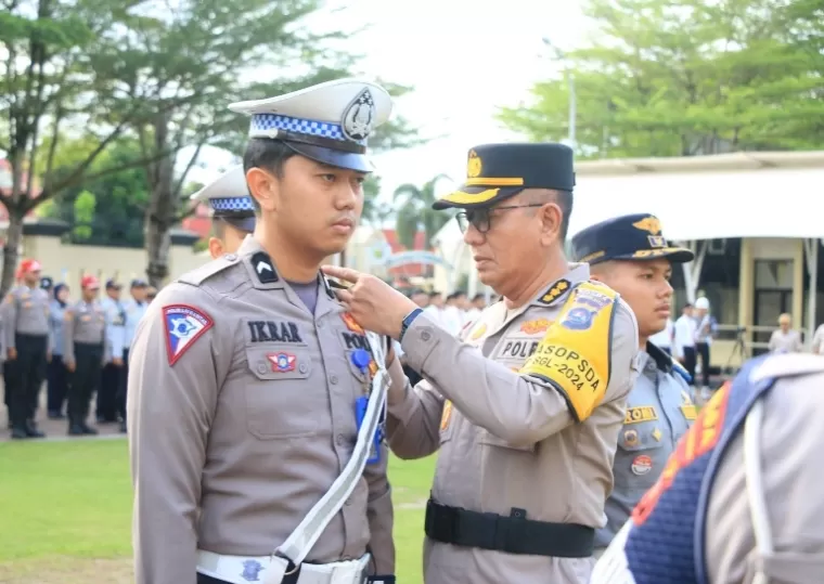 Irwasda Polda Sumbar, Kombes Pol Prabowo Santoso, pasangkan tanda resmi Operasi Singgalang 2024 kepada salah seorang anggota Satlantas di halaman Mapolda Sumbar, Senin (14/10/2024). (dok : istimewa)
