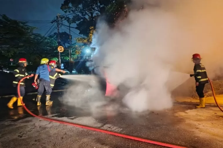 Beberapa orang petugas Damkar memadamkan api yang membakar satu unit mobil mahasiswa di area parkiran Kampus Kedokteran Unand, Jati, Sabtu malam (12/10/2024). (dok : damkar kota padang)