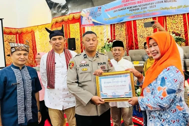 Anggota Polsek Lubeg, Aipda Dian Wihendro Rano selaku Bapak Asuh Anak Stunting (BAAS) di kecamatan itu menerima penghargaan dari Kepala perwakilan BKKBN Sumbar, Fatmawati, Jumat (11/10/2024). (dok : istimewa)