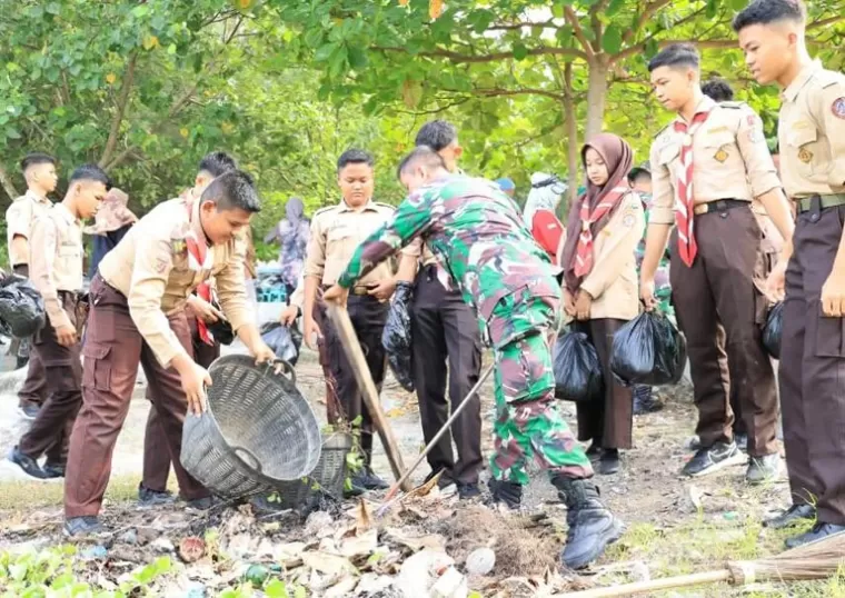 Personel Kodim 0308 Pariaman bersama anggota Pramuka bersihkan sampah yang ada di kawasan Pantai Gandoriah di Kota Pariaman, Kamis (3/10/2024). (dok : istimewa)