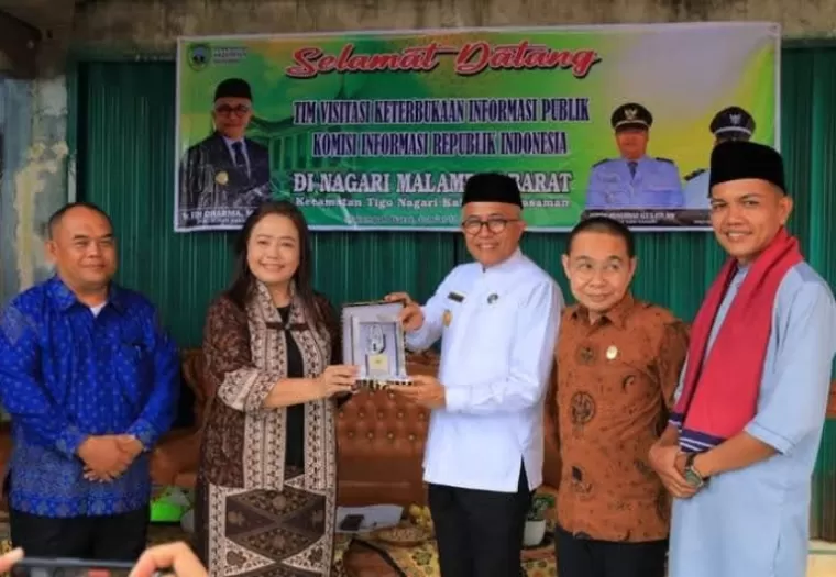 Komisioner KIP Rospita Vici Pauly serahkan plakat Apresiasi KIP Desa pada Nagari Malampah Barat yang diterima oleh Pjs Bupati Pasaman, Edi Dharma, Jumat (11/10/2024). IST