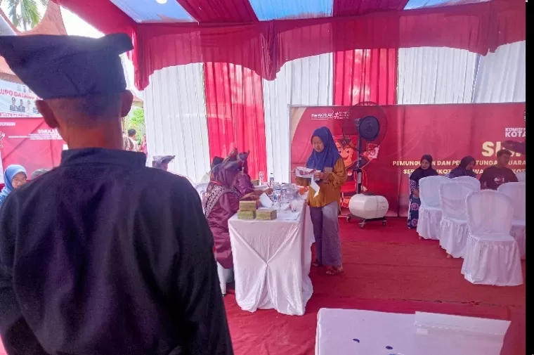 Seorang pemilih mendaftar pada petugas TPS saat simulasi pungut hitung yang diadakan KPU Padang di Kantor Camat Pauh, Kamis pagi (14/11/2024). (dok : arunala.com)