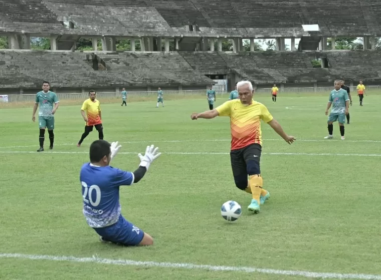 Gubernur Mahyedi menggiring bola menuju gawang lawan dalam pertandingan pertama kejuaraan sepakbola Piala Gubernur Antar instansi se Sumbar, Senin (2/12/2024). IST