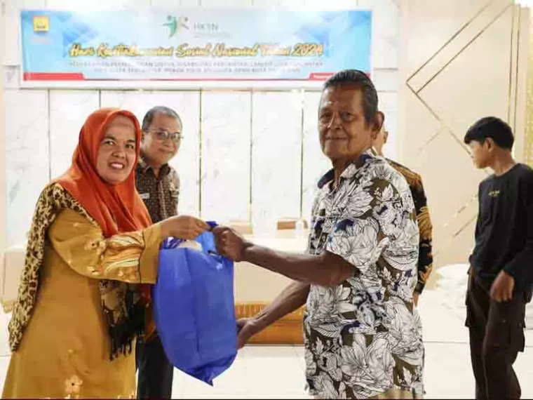 Staf Ahli Bidang SDM dan Kemasyarakatan Setko Pariaman, Hertati Taher serahkan bansos permakanan kepada salah satu perwakilan KPM di Pariaman Utara, Kamis (19/12/2024). IST