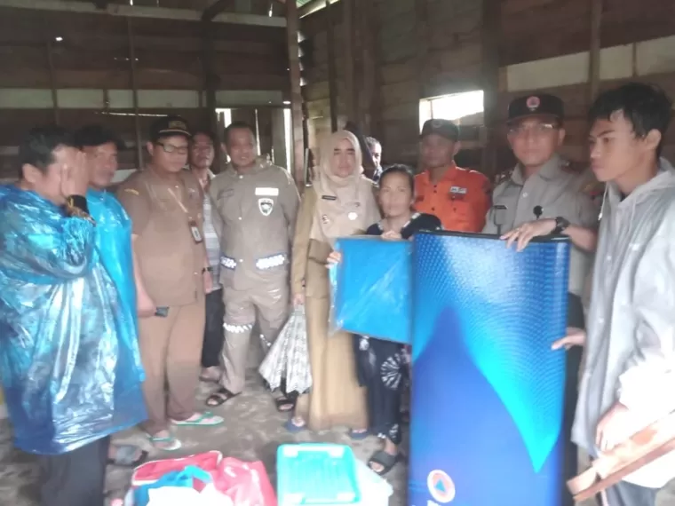 Pihak BPBD Kota Padang serahkan bantuan terpal dan lainnya pada warga, Senin (23/12/2024). IST